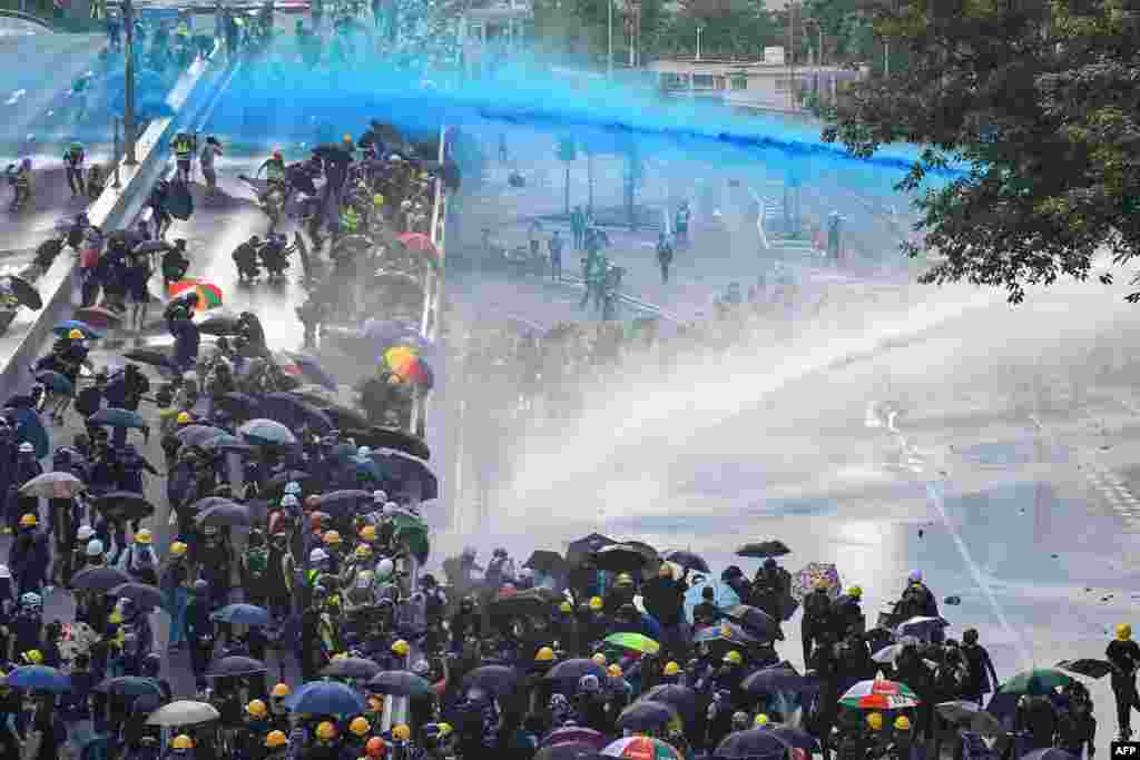 Pro-democracy protesters react as police fire water cannons outside the government headquarters in Hong Kong.