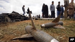 People look at components of AIM-9 Sidewinder air-to-air missiles from a U.S Air Force F-15E fighter jet after it crashed near the eastern city of Benghazi March 22, 2011
