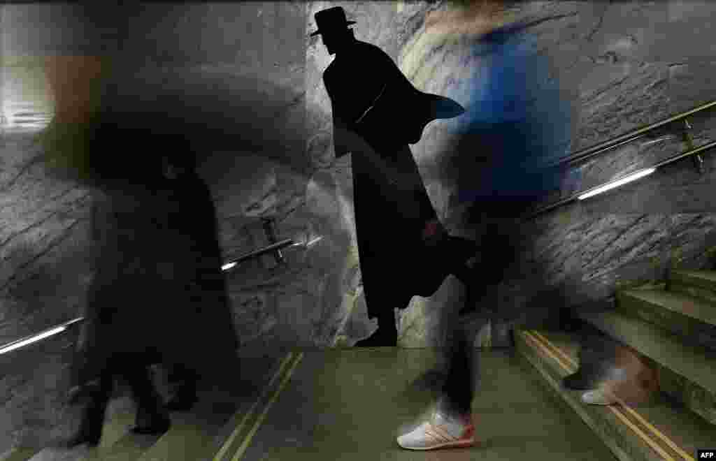 Para penumpang menuruni tangga di stasiun kereta bawah tanah Dostoyevskaya di Moskow, Rusia.