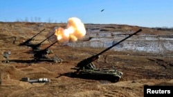 FILE - North Korea's artillery sub-units, whose mission is to strike Daeyeonpyeong island and Baengnyeong island of South Korea, conduct a live shell firing drill to examine war fighting capabilities in the western sector of the front line in this picture
