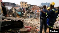 Rescuers are seen as people search for belongings at the site of a collapsed building in Nigeria's commercial capital of Lagos, Nigeria, March 14, 2019. 