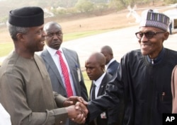 FILE - Nigeria President Muhammadu Buhari (right) is welcomed by Nigeria Vice President Yemi Osinbajo (left) upon arrival from his medical vacation in Abuja, Nigeria, March 10, 2017.