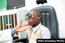Lemuel Tebuck, now 8 years old, with aligned eyes from strabismus surgery, undergoes a regular check-up at Yaoundé Central Hospital, Yaoundé, Cameeroon, April 2016.