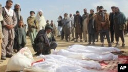 FILE - Afghan villagers gather around several victims of clashes between Taliban and Afghan security forces in the Taliban-controlled, Buz-e Kandahari village in Kunduz province, Afghanistan, Nov. 4, 2016. 