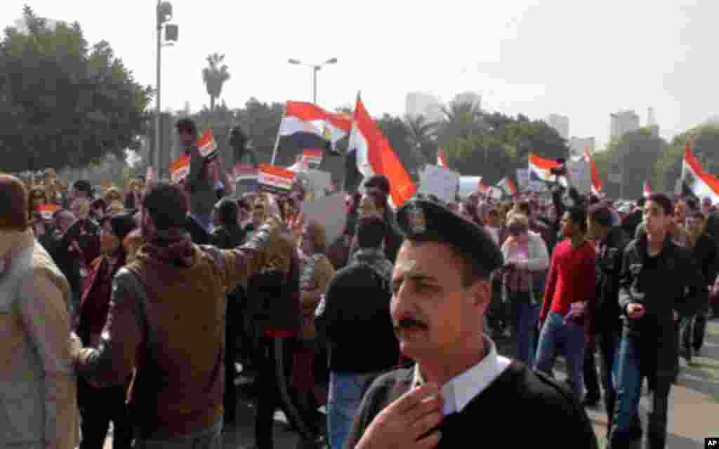 Security escorts protesters headed for Tahrir Square, Cairo, January 23, 2012. (VOA - E. Arrott)