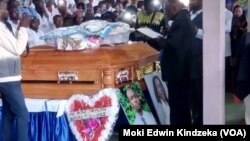 Photos of slain nurses Nancy Azah and her husband, Njong Padisco, lean against their coffins during funeral services in Alahkuma, Aug. 15, 2018.