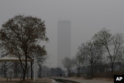 FILE - A man wears a face mask as he walks near the Han river at a park in a smog-covered Seoul, South Korea, Jan. 14, 2019. Unusually high levels of smog worsened by weather patterns are raising alarm across Asia.