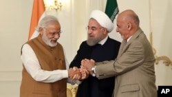 Dari kiri: PM India Narendra Modi, Presiden Iran Hassan Rouhani, dan Presiden Afghanistan Ashraf Ghani saling berjabat tangan pasca penandatanganan kerjasama di Teheran, Senin (23/5).