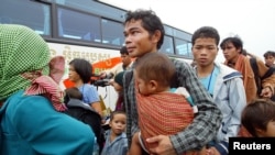 FILE -- Montagnard hill tribe members board bus after arriving at Phnom Penh International airport, July 28, 2004.