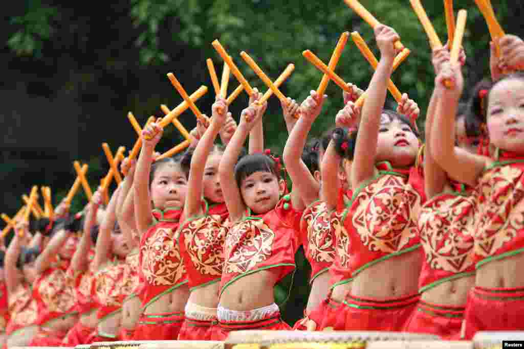 ក្មេងៗស្លៀកសម្លៀកបំពាក់ប្រពៃណី សម្តែងជាមួយនឹងស្គរ ក្នុងទីក្រុង Guangan ខេត្ត Sichuan ប្រទេសចិន។