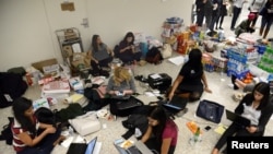 In this file photo, lawyers and legal assistants network and use social media in the baggage claim area at Dulles International Airport, aiding passengers who have arrived and encounter problems because of Donald Trump's travel ban to the United States, Jan. 29, 2017.