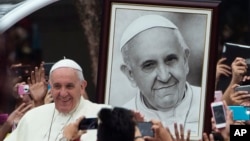 Le pape François vient de passer son portrait alors qu'il arrive à une réunion des jeunes à l'université de Santo Tomas à Manila, Philippines, le 18 janvier 2015.
