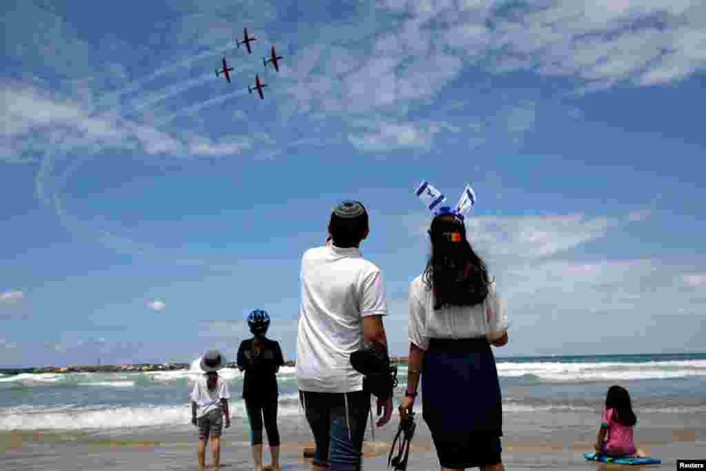 People watch as Israeli Air Force planes fly over the Mediterranean Sea during an aerial show as part of the celebrations for Israel&#39;s Independence Day marking the 71st anniversary of the creation of the state, in Tel Aviv.