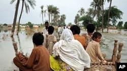 Pakistani villagers make their way through flood waters in Baseera, Pakistan, 24 Aug 2010