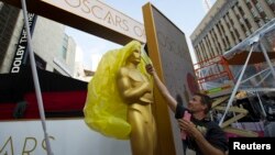 An Oscar statue is uncovered outside the Dolby Theater during preparations leading up to the 87th Academy Awards in Hollywood, California, Feb. 21, 2015.