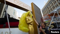 An Oscar statue is uncovered outside the Dolby Theater during preparations leading up to the 87th Academy Awards in Hollywood, California, Feb. 21, 2015.