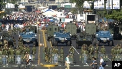 FILE - The military creates a perimeter at a government-subsidized food market in Caracas, Venezuela, Feb. 14, 2004.
