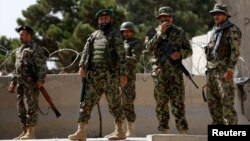 Afghan National Army (ANA) soldiers keep watch at the gate of a British-run military training academy Camp Qargha, in Kabul, Aug. 5, 2014. 