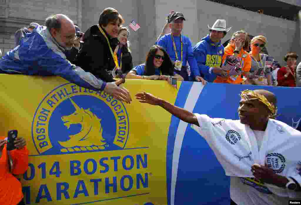 Meb Keflezighi dari AS (kanan) mendapatkan ucapan selamat setelah memenangkan kategori putra dalam Boston Marathon ke-118. Keflezighi adalah atlet pria pertama AS yang memenangkan Boston Marathon selama tiga dekade, Boston, Mass., 21 April 2014.