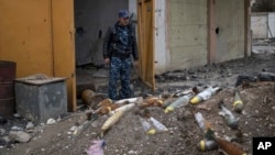 FILE - A member of the Federal Police stands next to unexploded bombs left by Islamic State group militants on the western side of Mosul, Iraq, March 22, 2017.