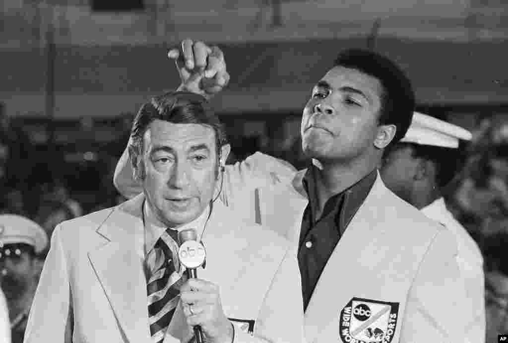 FILE - Muhammad Ali, former world heavyweight boxing champion, toys with the finely combed hair of television sports commentators Howard Cosell before the start of the Olympic boxing trials, in West Point, N.Y., Aug. 7, 1972.