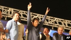 تحریکِ انصاف کے سربراہ عمران خان ایک جلسے میں حامیوں کے نعروں کا جواب دے رہے ہیں (فائل فوٹو)