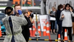 In this April 17, 2020, file photo, medical staff test shoppers who volunteered at a pop-up community COVID-19 testing station at a supermarket carpark in Christchurch, New Zealand. (AP Photo/Mark Baker, File)