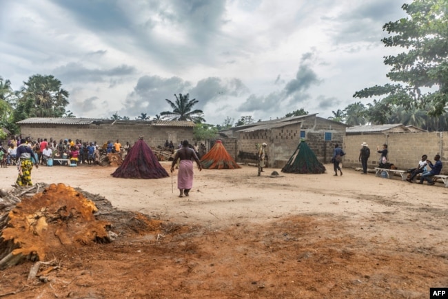 Residents dance near the Zangbeto during a ceremony for the guardian of the night Zangbeto a traditional voodoo of the Yoruba religion, in the village of Alongo on May 14, 2018.