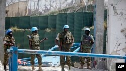 Des soldats des Nations Unies se tiennent devant le portail détruit du bureau des Nations Unies à Mogadiscio en Somalie, le mardi 26 juillet 2016 (Photo AP / Farah Abdi Warsameh)