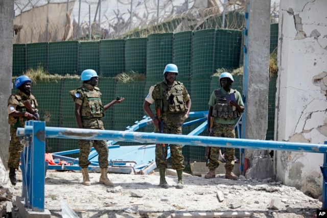 United Nations soldiers stand in front of the destroyed gate outside the UN's office in Mogadishu, Somalia on July, 26, 2016.