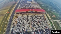 Vehicles are seen stuck in a traffic jam near a toll station as people return home at the end of a week-long national day holiday, in Beijing, China, October 6, 2015.