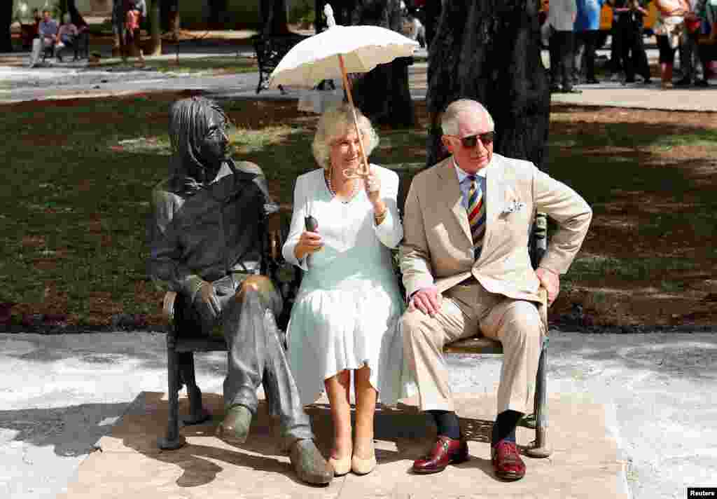 Britain&#39;s Prince Charles and Camilla, Duchess of Cornwall, sit on a bench at John Lennon Park in Havana, Cuba.