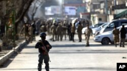 Afghan security forces inspect the site of a suicide attack at the gate of a Civil Order Police compound, in Kabul, Afghanistan, Monday, Feb. 1, 2016. 