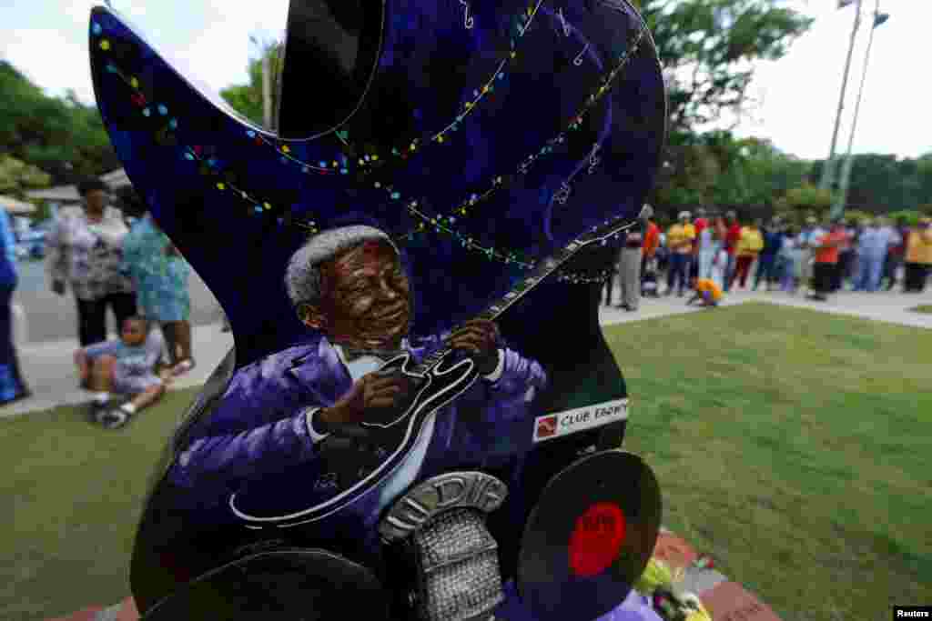 Warga melintasi patung Lucille, gitar BB King, di museum BB King di Indianola, Mississippi. Publik dapat memberi penghormatan mereka terhadap Raja Musik Blues ini, yang disemayamkan di museumnya. King meninggal dunia dalam usia 89 tahun di rumahnya di Las Vegas.