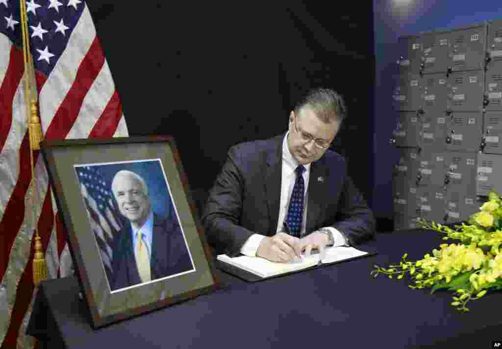 U.S. Ambassador to Vietnam Daniel Kritenbrink writes a note in a book of condolences for the late U.S. Senator John McCain in Hanoi, Vietnam, Aug. 27, 2018.