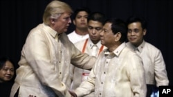 川普总统在马尼拉的东盟晚宴上与菲律宾总统杜特尔特握手（2017年11月12日）