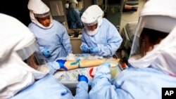 FILE- Members of the U.S. Department of Defense's Ebola Military Medical Support Team go through special training at San Antonio Military Medical Center.