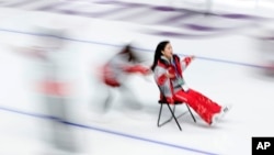 A volunteer pushes another volunteer on a chair on the ice after the last speedskating race at the Gangneung Oval at the 2018 Winter Olympics in Gangneung, South Korea, Feb. 24, 2018.