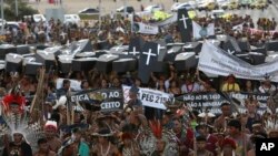 FILE - Indigenous protesters from various ethnic groups carry fake coffins representing Indians killed over the demarcation of land, as they demand the demarcation of indigenous lands, outside the National Congress in Brasilia, Brazil, April 25, 2017.