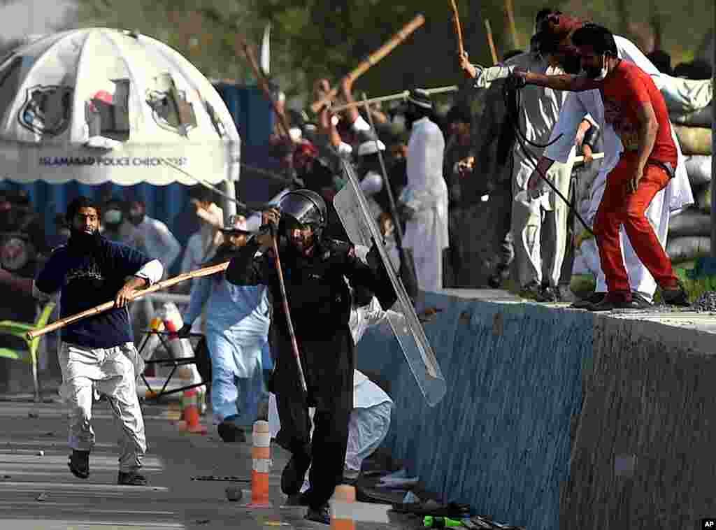 Pakistani protesters beat a paramilitary soldier during clashes near the parliament building in Islamabad to protest the hanging of a man charged with murdering a secular governor.