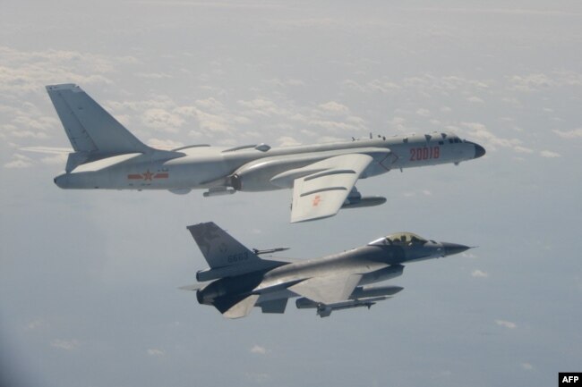 FILE - A Taiwanese F-16 fighter jet flies next to a Chinese H-6 bomber, top, in Taiwan's airspace, in this handout photo taken and released on February 10, 2020, by Taiwan's Defence Ministry.