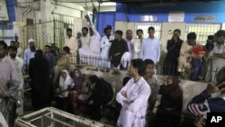 Quelques personnes se rassemblent devant le service d'urgence d'un hôpital local après un attentat suicide dans un sanctuaire soufi, à Karachi, au Pakistan, 12 novembre 2016.