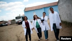 FILE - Cuban doctor Elza Vega Rodriguez (2nd L) walks with her Brazilian team of assistants near the health center where they work, in Piaus, north-eastern Brazil, Nov. 20, 2013.