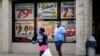 Orang-orang tampak keluar dari Supermarket Piggly Wiggly di mana terdapat beberapa poster yang berisi seruan penghormatan terhadap para veteran terpasang di jendela supermarket yang terletak di Columbus, Georgia, pada 8 September 2020. (Foto: Reuters/Elijah Nouvelage)