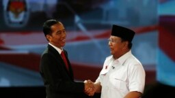 Calon presiden Indonesia Jokowi berjabat tangan dengan Prabowo Subianto sesudah acara debat presiden (15/6). Dalam masa kampanye presiden ini banyak terjadi kampanye hitam seperti misalnya penyebaran tabloid Obor Rakyat yang berisi fitnah terhadap Jokowi. 