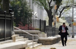 FILE - A pedestrian walks down a street as pollen litters the sidewalk outside the State Capitol Tuesday, March 20, 2012, in Atlanta. (AP Photo/David Goldman)