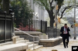 FILE - A pedestrian walks down a street as pollen litters the sidewalk outside the State Capitol Tuesday, March 20, 2012, in Atlanta. (AP Photo/David Goldman)