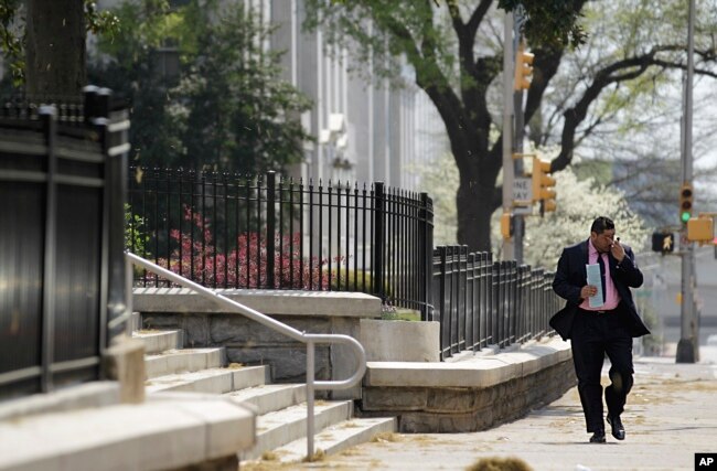 FILE - A pedestrian walks down a street as pollen litters the sidewalk outside the State Capitol Tuesday, March 20, 2012, in Atlanta. (AP Photo/David Goldman)