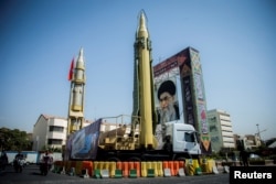 FILE - A display featuring missiles and a portrait of Iran's Supreme Leader Ayatollah Ali Khamenei is seen at Baharestan Square in Tehran, Iran, Sept. 27, 2017.