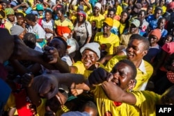 Supporters of ZANU PF cheer for their candidates for parliament after a ZANU PF election campaign rally addressed by Vice President Constantino Chiwenga at a school near Harare, on July 27, 2018.